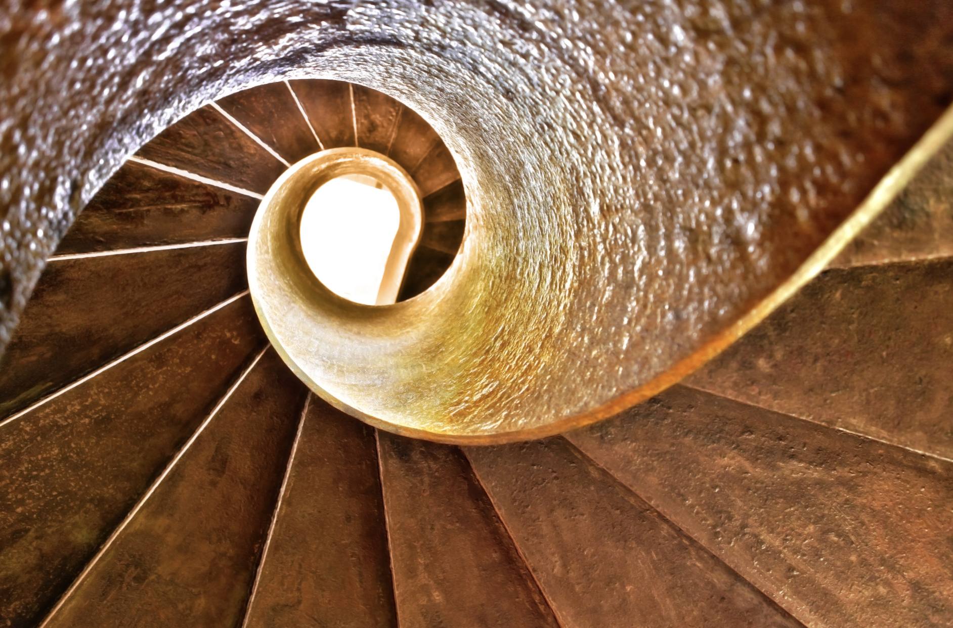 A descending spiral staircase, a visual metaphor for the layers of oversight required to manage AI agents safely